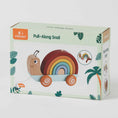 Load image into Gallery viewer, Packaging for the pull-along snail toy, featuring a colorful, eye-catching design. The box displays the rainbow-colored wooden snail toy, highlighting its non-toxic paint and suitability for toddlers 12 months and older.