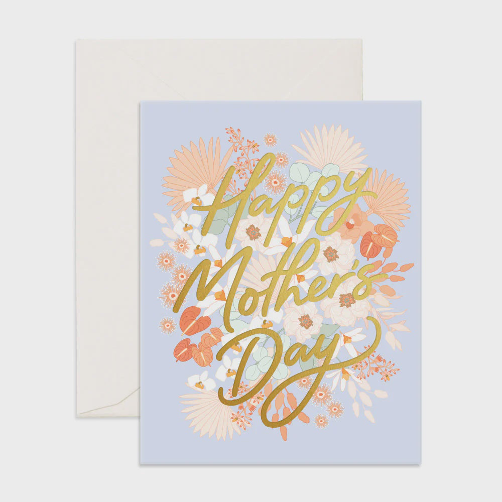 An envelope with a greeting card on top, featuring a floral design in pink and white tones on a light blue background, with "Happy Mother's Day" in gold foil.