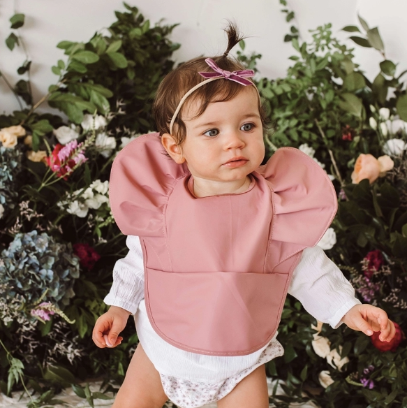 Primrose Snuggle Bib in a stylish design, featuring waterproof, easy-to-wipe material, an adjustable neck strap, and a handy pocket for catching spills.