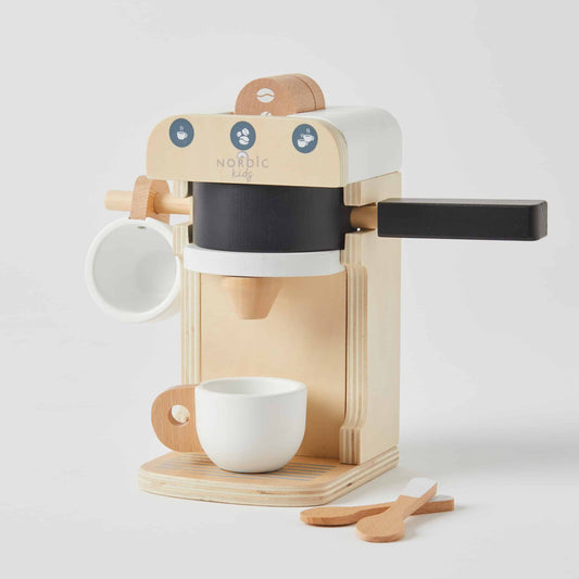 A wooden coffee machine playset with black, white, and natural wood accents, complete with cups, spoons, and a bean grinder, perfect for imaginative play.