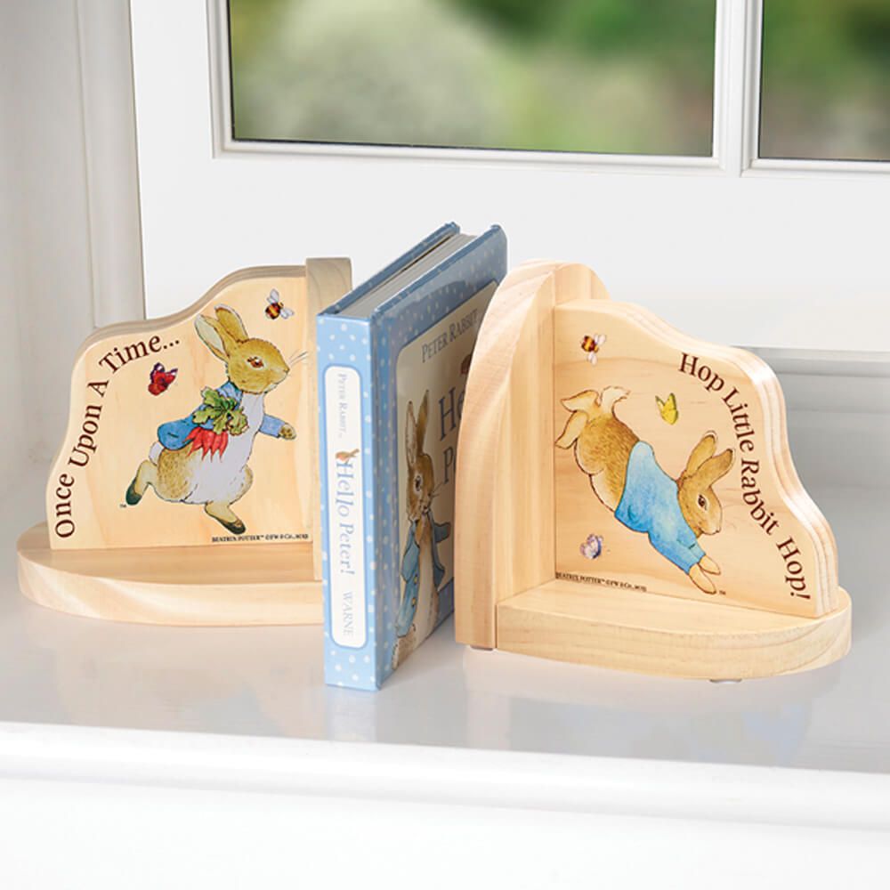 Charming Peter Rabbit wooden bookends with classic illustrations and quotes, perfect for a nursery shelf.